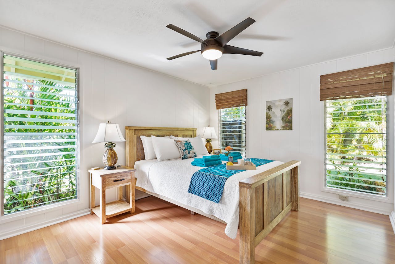 why-choose-us Sunny tropical bedroom with wooden furniture, teal accents, and lush greenery views.